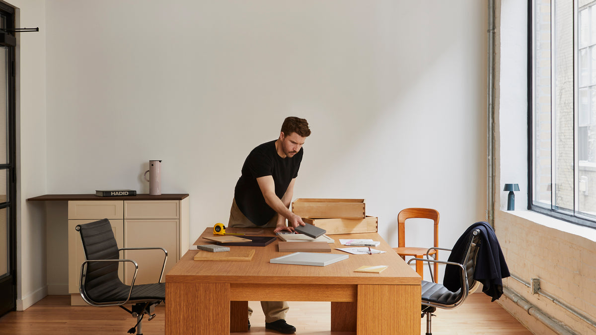 A PALET designer laying out door samples at a desk in the Toronto studio