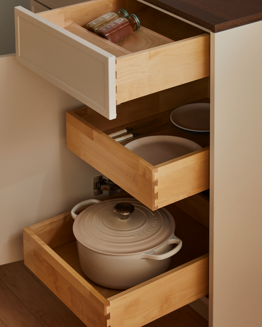 Open wood dovetail drawers holding cookware